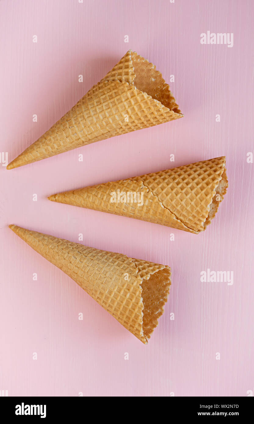 Three empty waffle cones on a pink background. Flat lay. Minimalism. Stock Photo