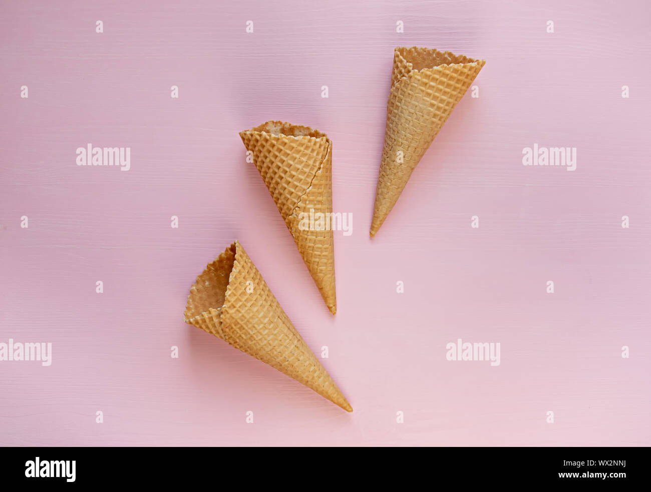 Three empty waffle cones on a pink background. Flat lay. Minimalism. Stock Photo