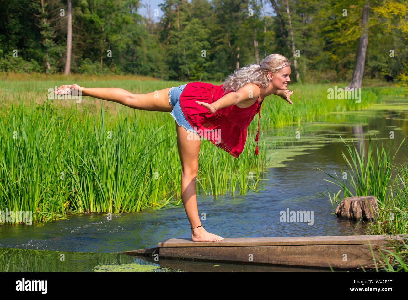 Woman in yoga posture on one leg in nature Stock Photo