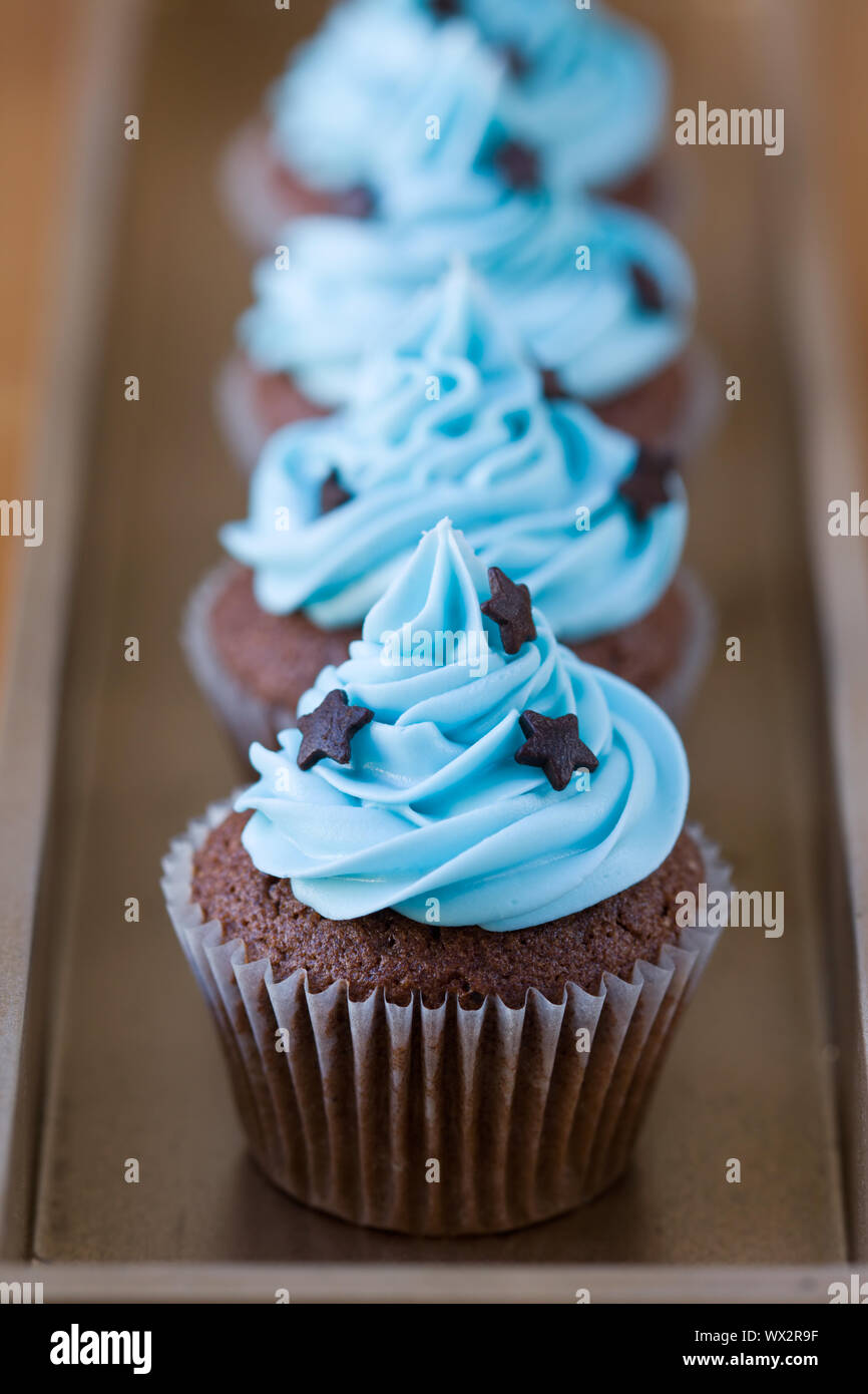 Row of miniature chocolate cupcakes decorated with stars Stock Photo