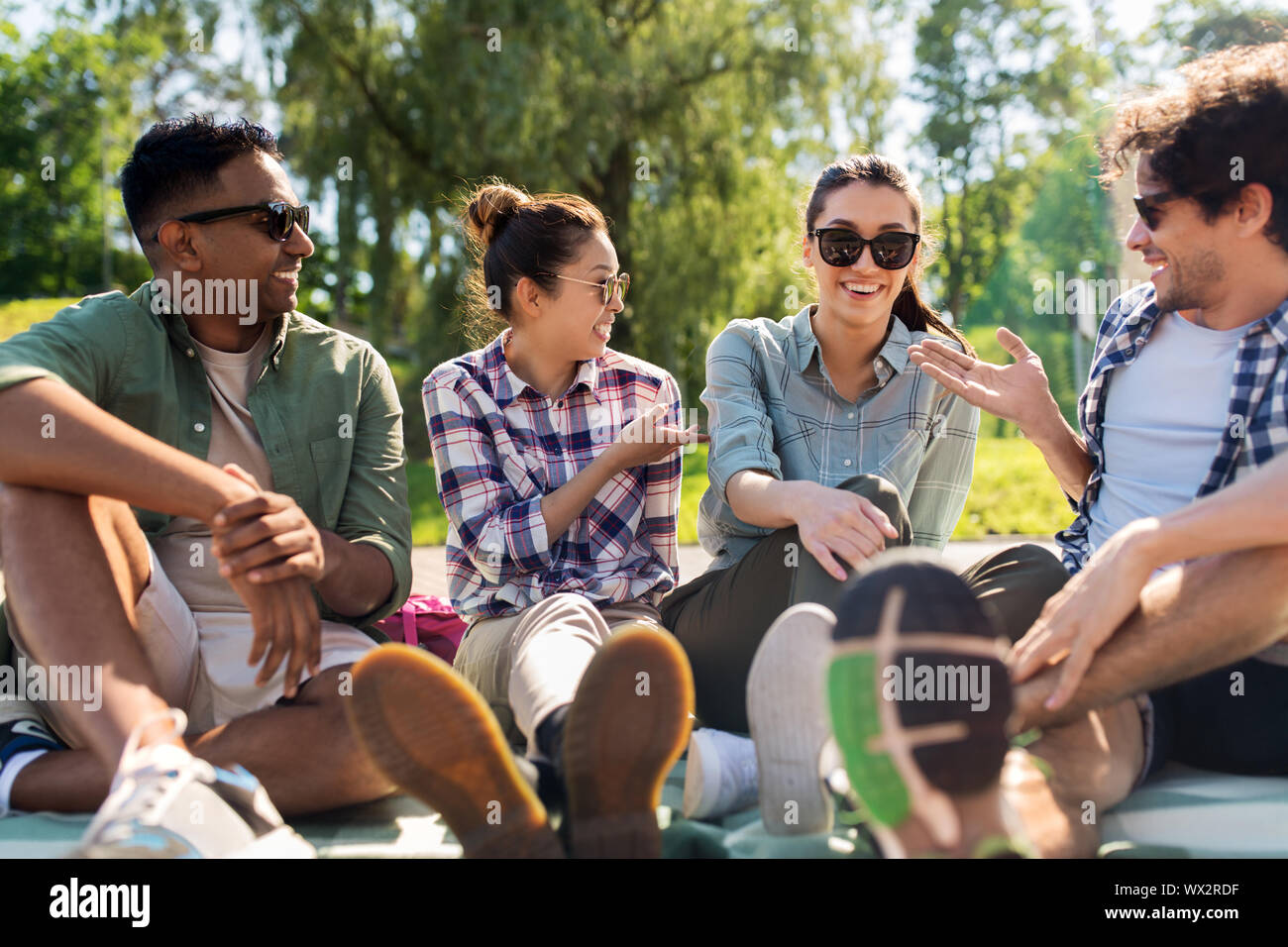 friends hanging out and talking outdoors in summer Stock Photo - Alamy