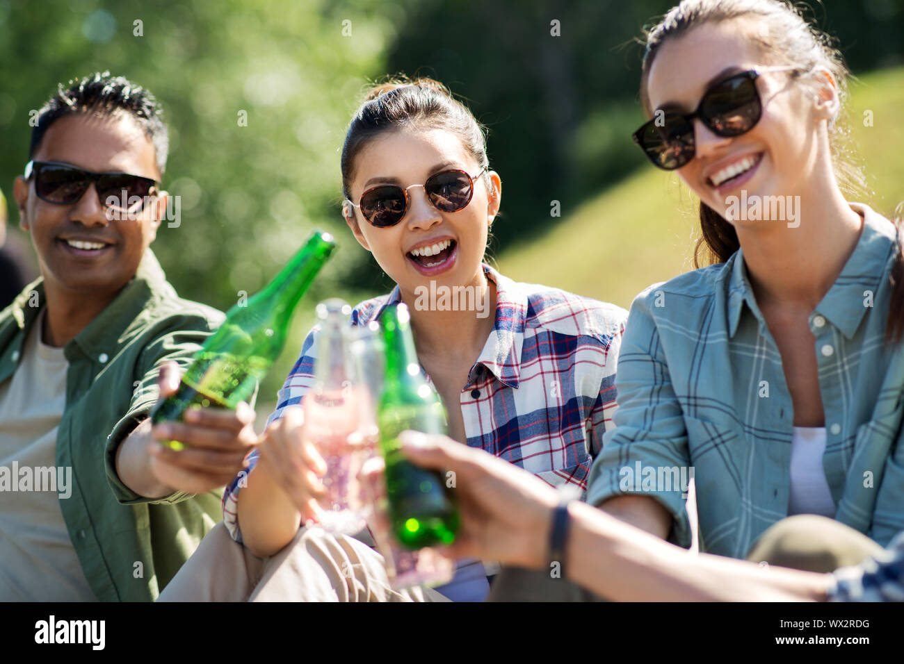 happy friends clinking drinks outdoors in summer Stock Photo