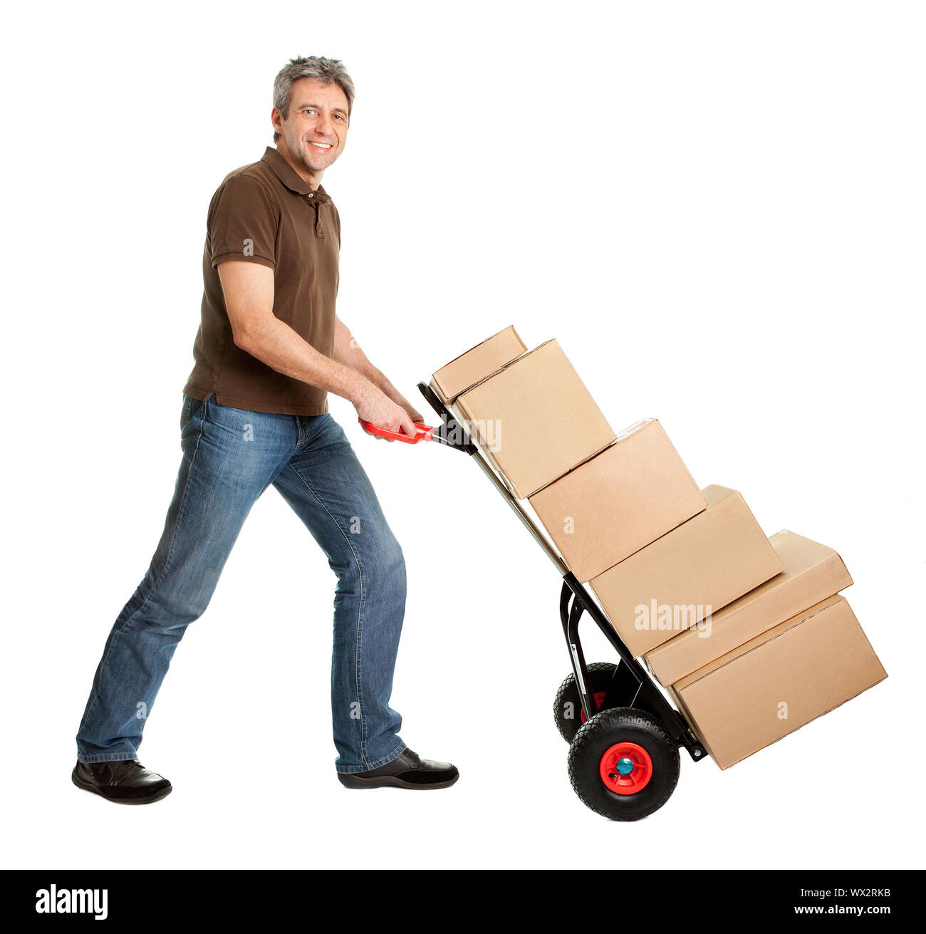 Delivery man pushing hand truck and stack of boxes Stock Photo