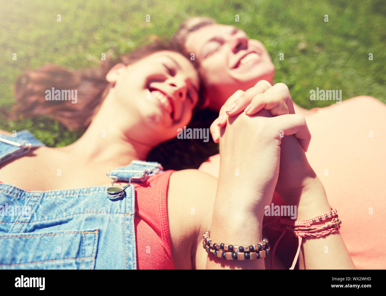 happy teenage couple lying on grass at summer Stock Photo - Alamy