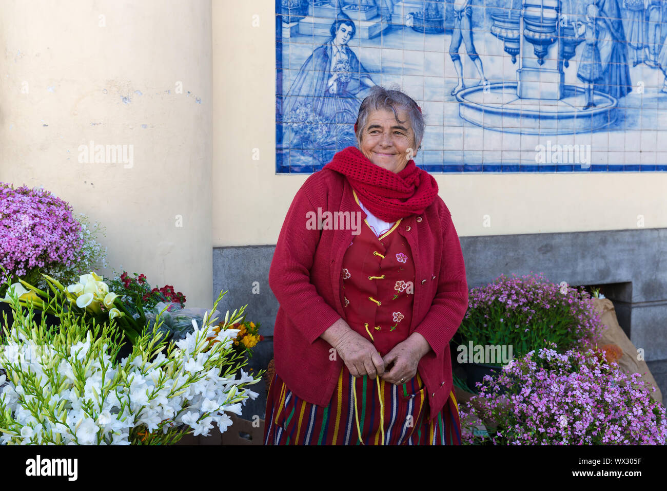 Traditional woman sells flowers at a market of Funchal, Portugal Stock Photo