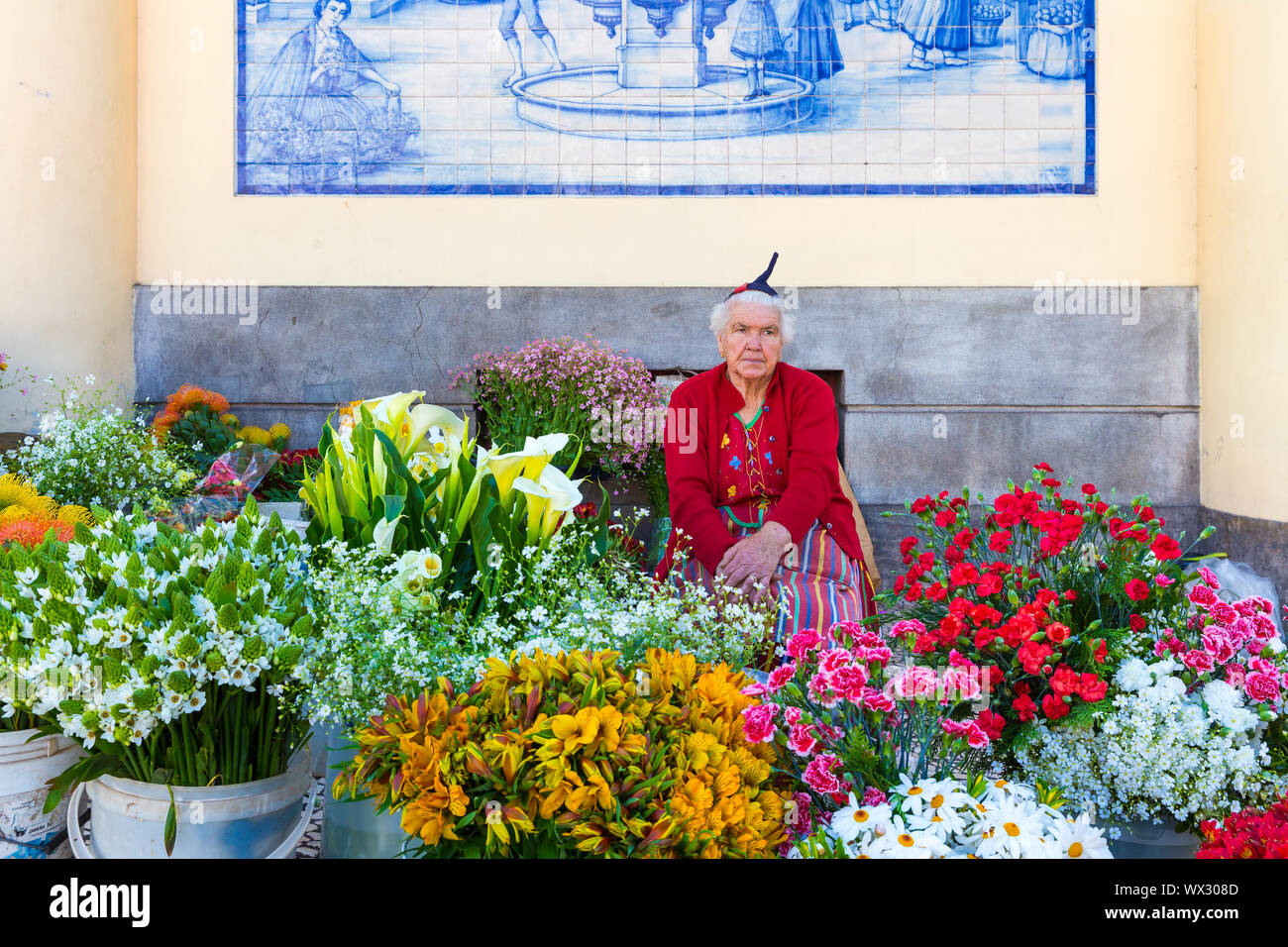Traditional woman sells flowers at a market of Funchal, Portugal Stock Photo