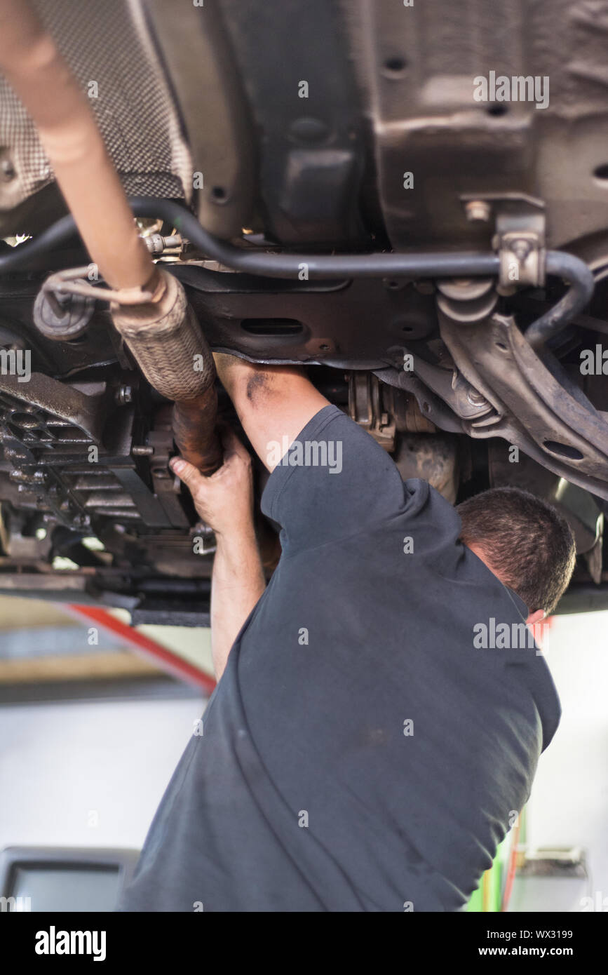 Mechanic repairing exhaust system Stock Photo Alamy