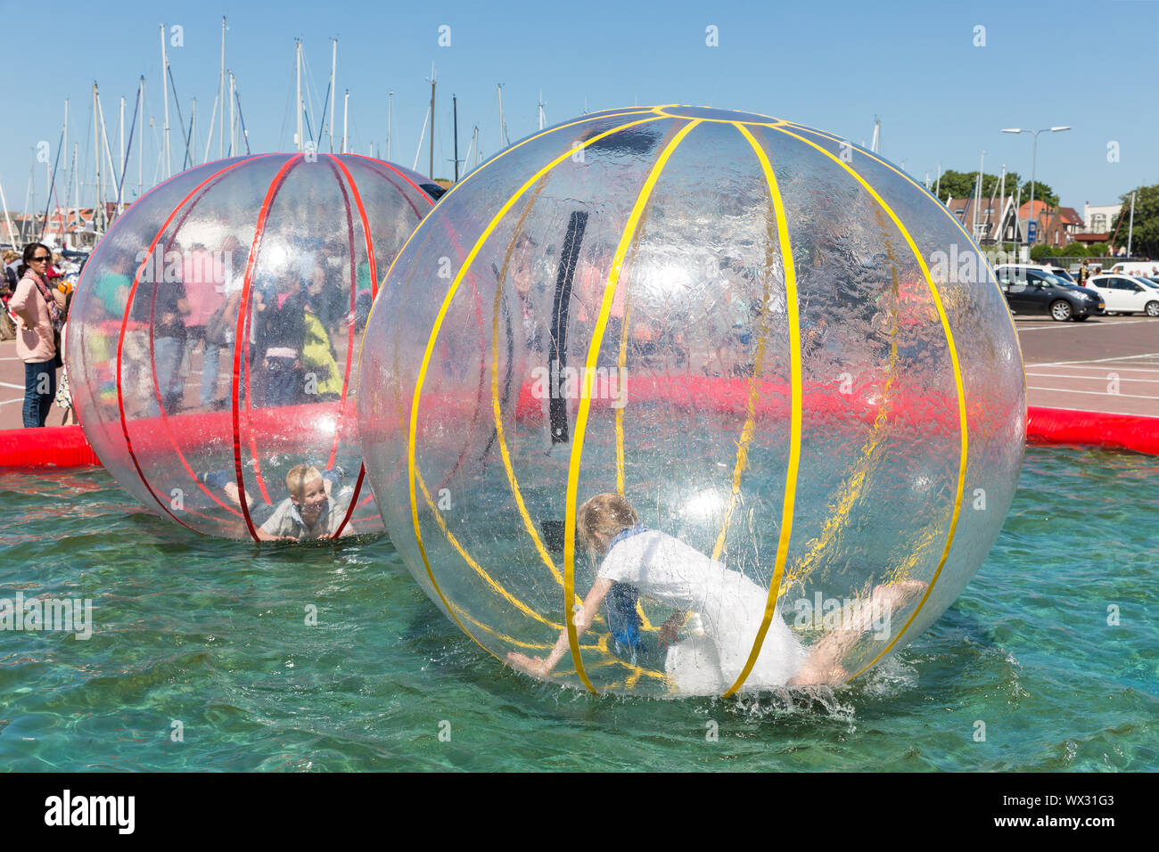 Ondraaglijk Verdikken Productie Children have fun inside plastic balloons on the water during a fishing  fare Stock Photo - Alamy