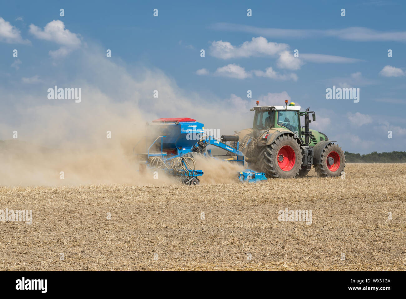 Tractor with a sowing machine working in the field Stock Photo