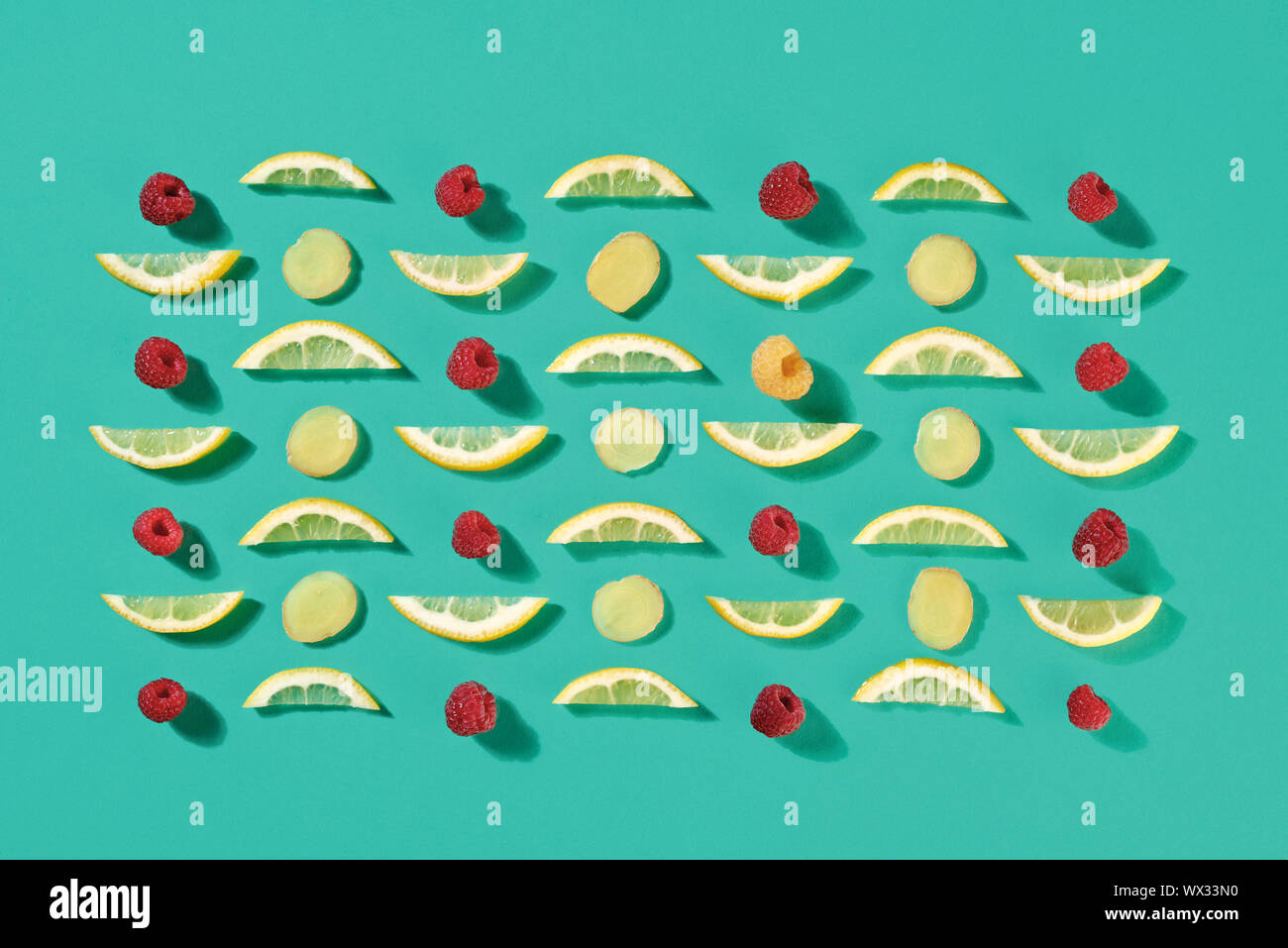 Ripe raspberry and lemon slices pattern of fruit on a blue background. Food layout. Flat lay Stock Photo