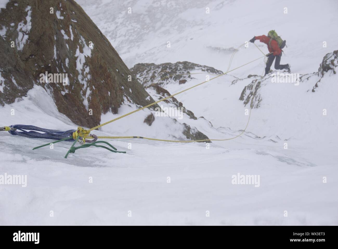 mountain climber rappelling in bad weather Stock Photo Alamy