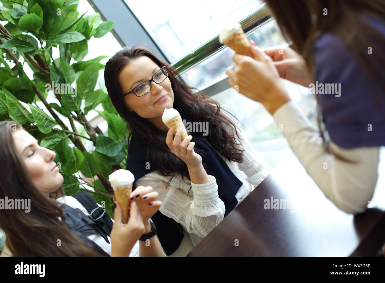 women on foreground licking ice cream Stock Photo Alamy
