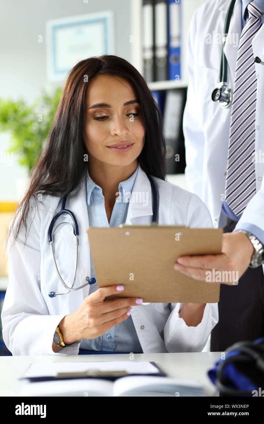 Two physicians discussing important documents clipped to pad Stock ...