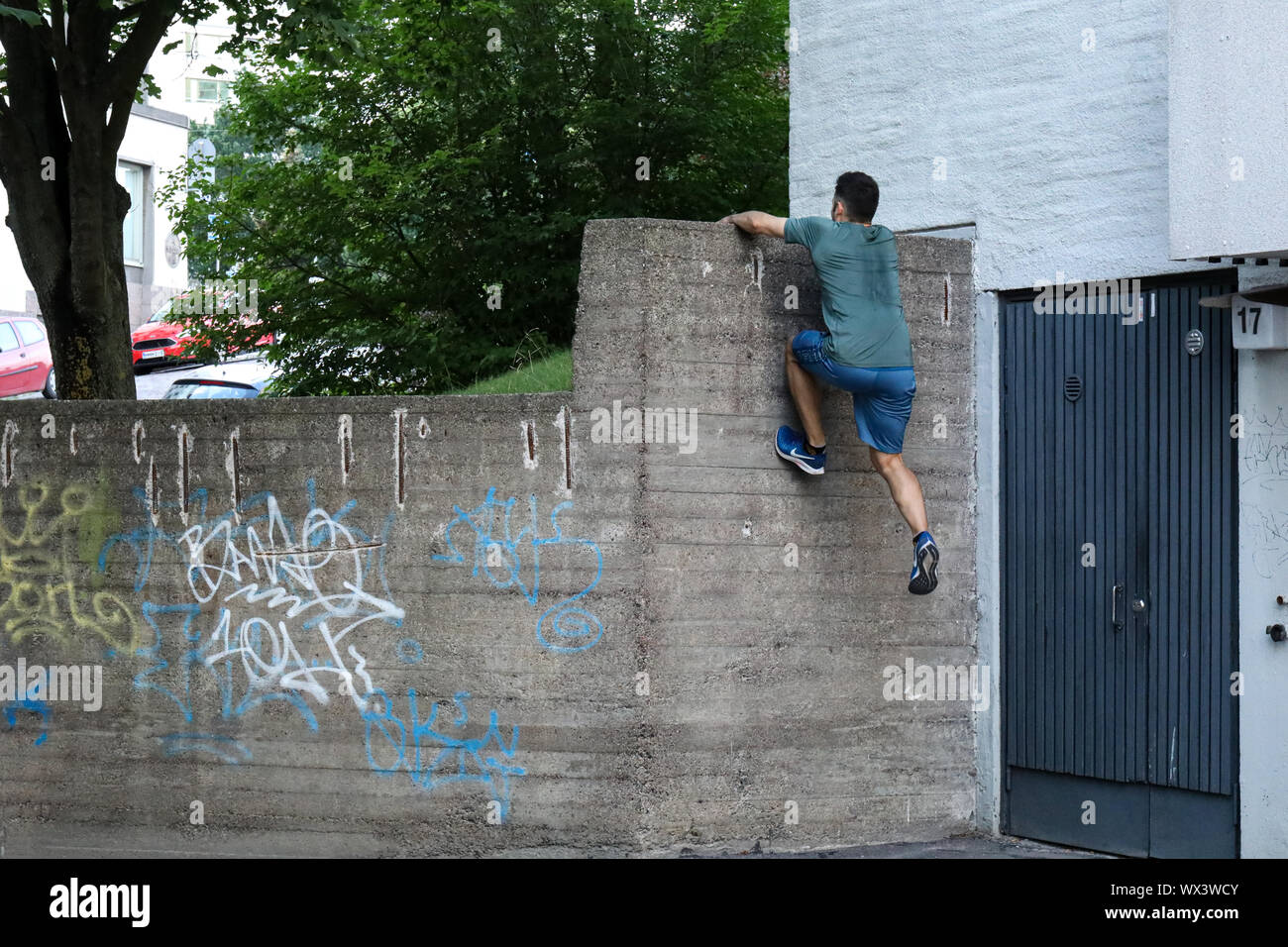 Parkour traceur climbing a wall Stock Photo Alamy