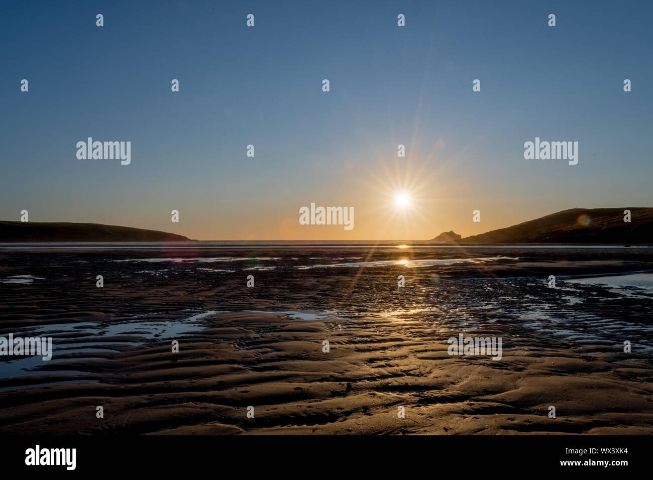 Landscape photo of the sun setting over Crantock beach in Cornwall Stock Photo
