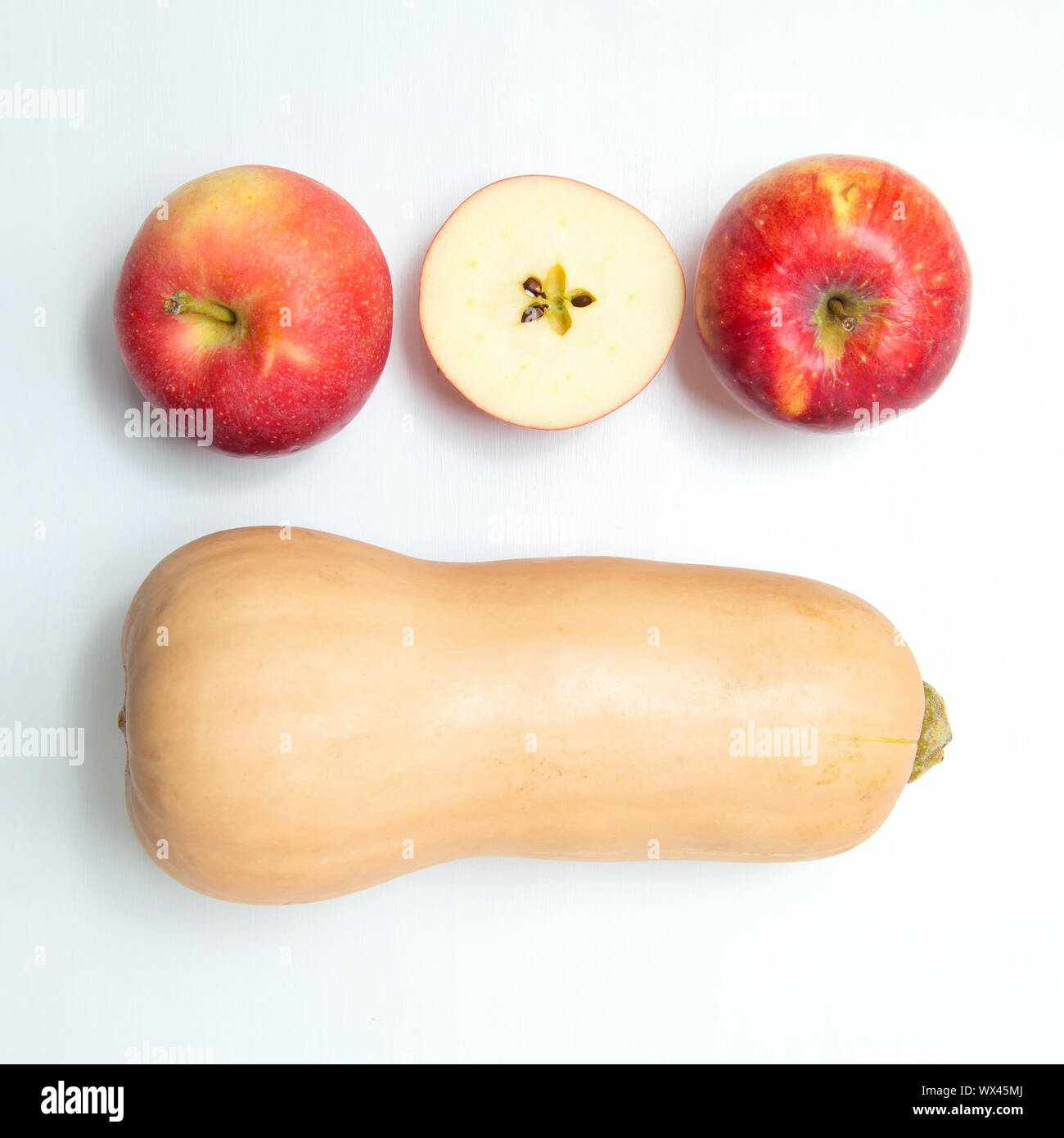 Yellow pumpkin and three apples on a white background. Stock Photo