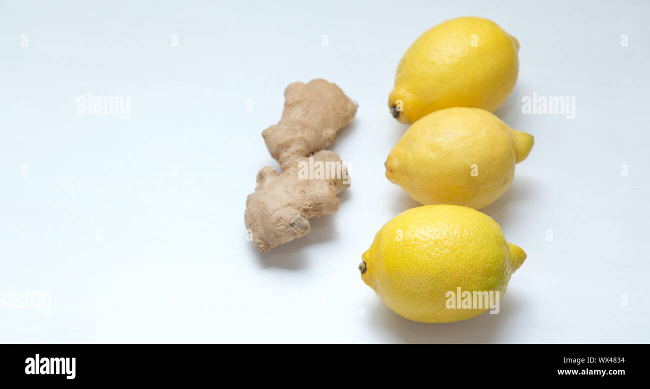 Three yellow lemons and ginger root on a light background. Stock Photo