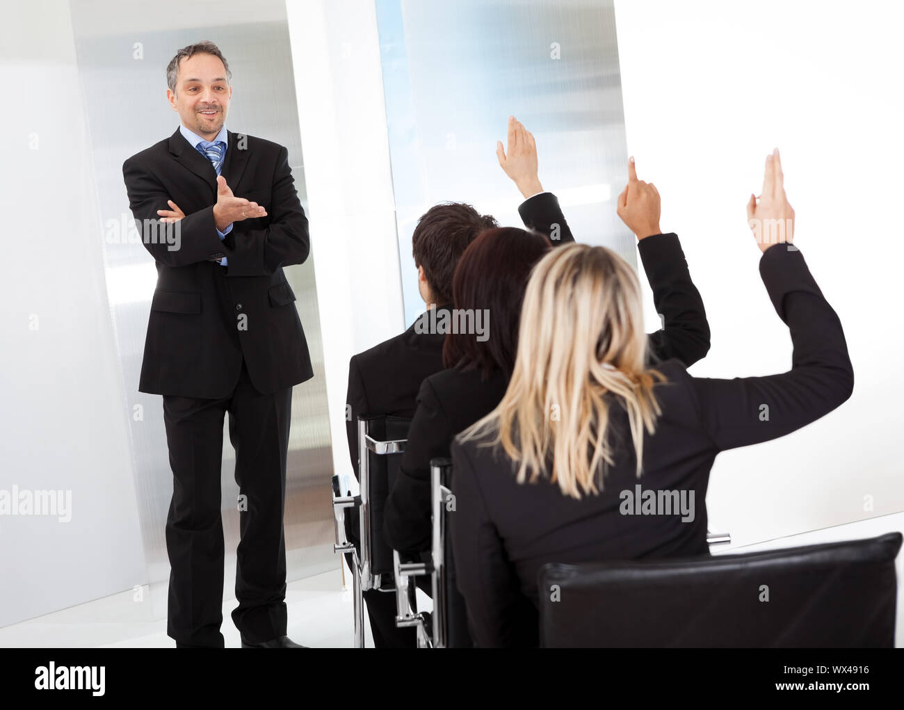 Group of successful business people at the lecture asking questions