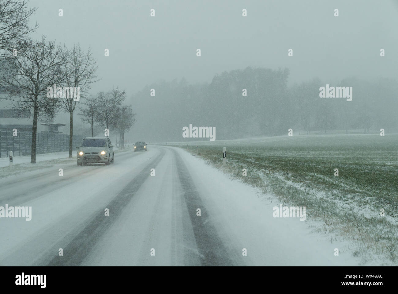 snow storm on a country road and dangerous road conditions in winter ...