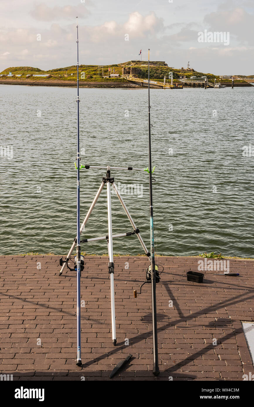 professional sea fish rod placed diagonally on a tripod standard on the quay near the sea Stock Photo