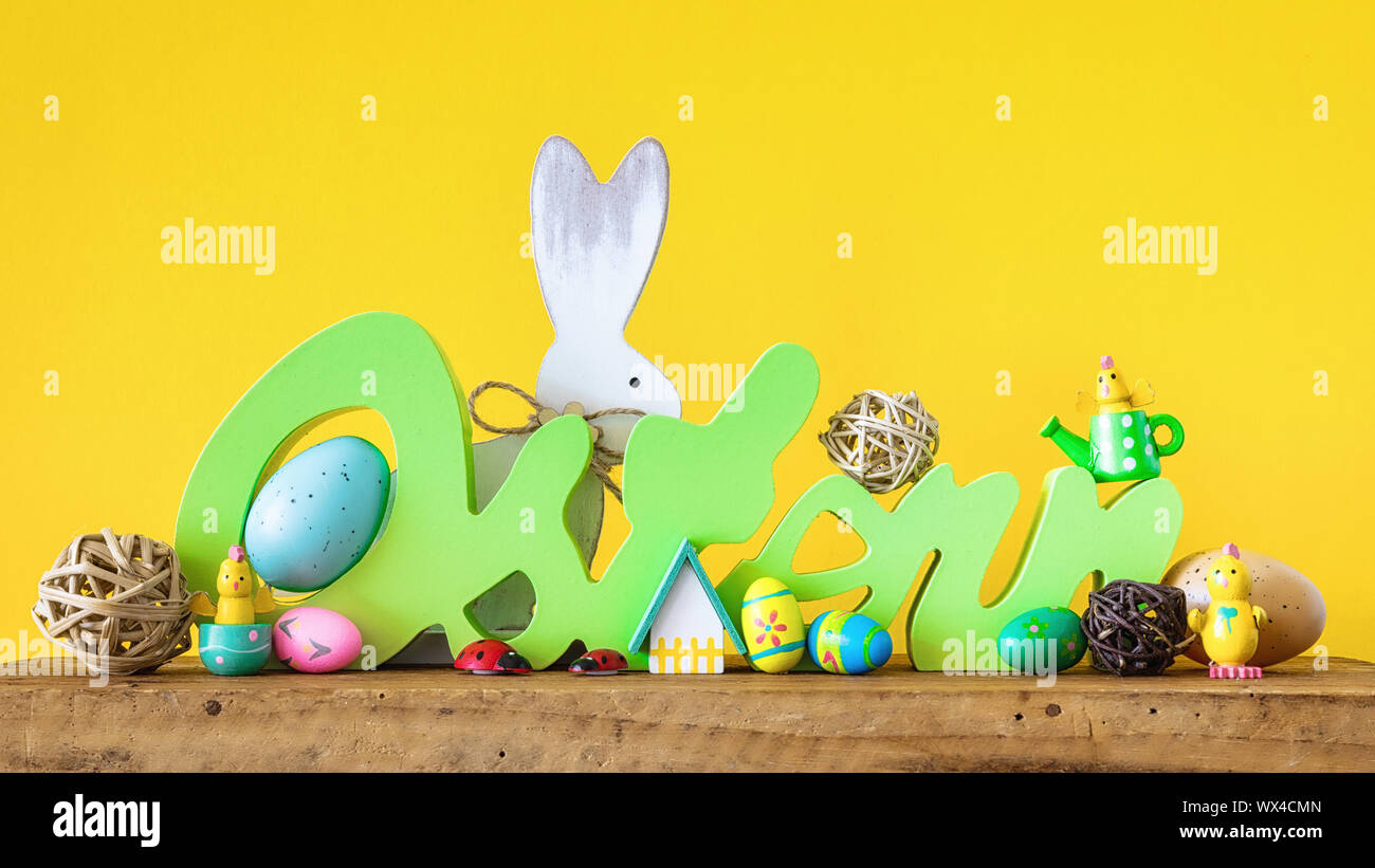 Word Easter in german language with easter bunny eggs and chicks Stock