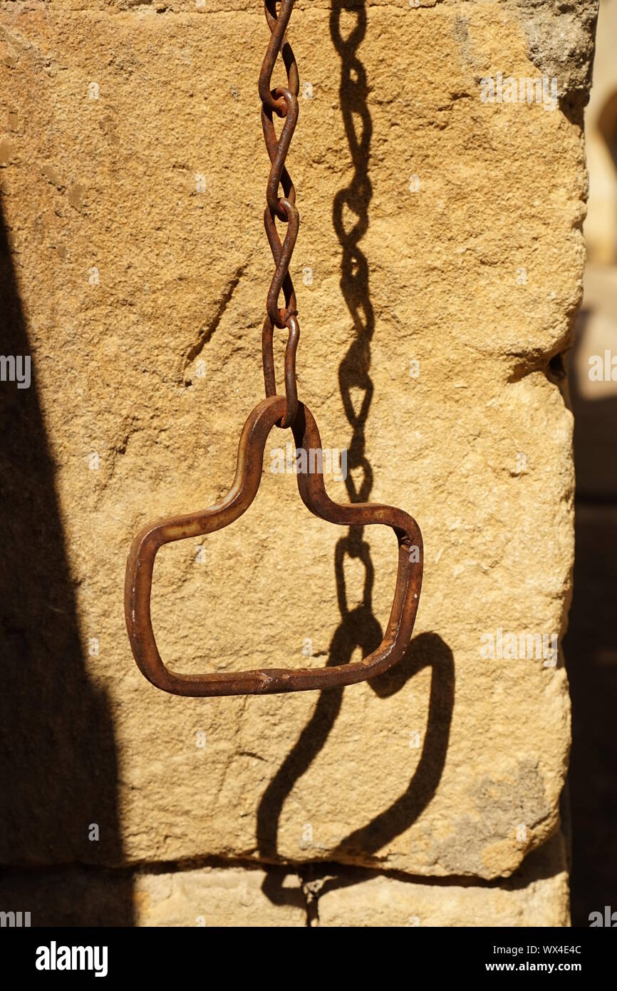 Old metal rusty pull chain hanging in a French village Stock Photo