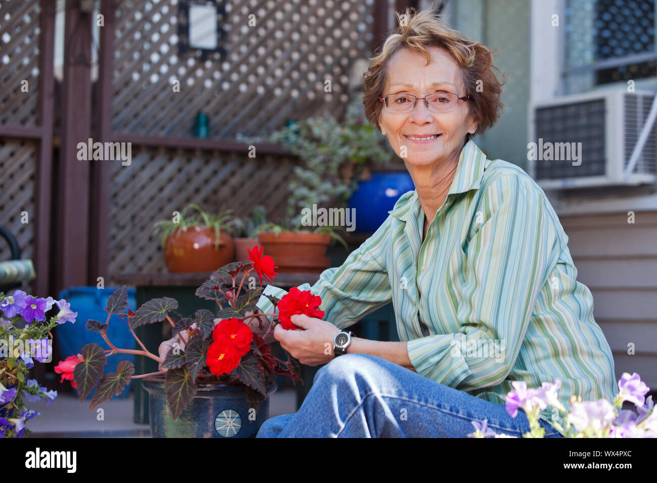 Portrait of smiling senior woman with potted plant Stock Photo - Alamy