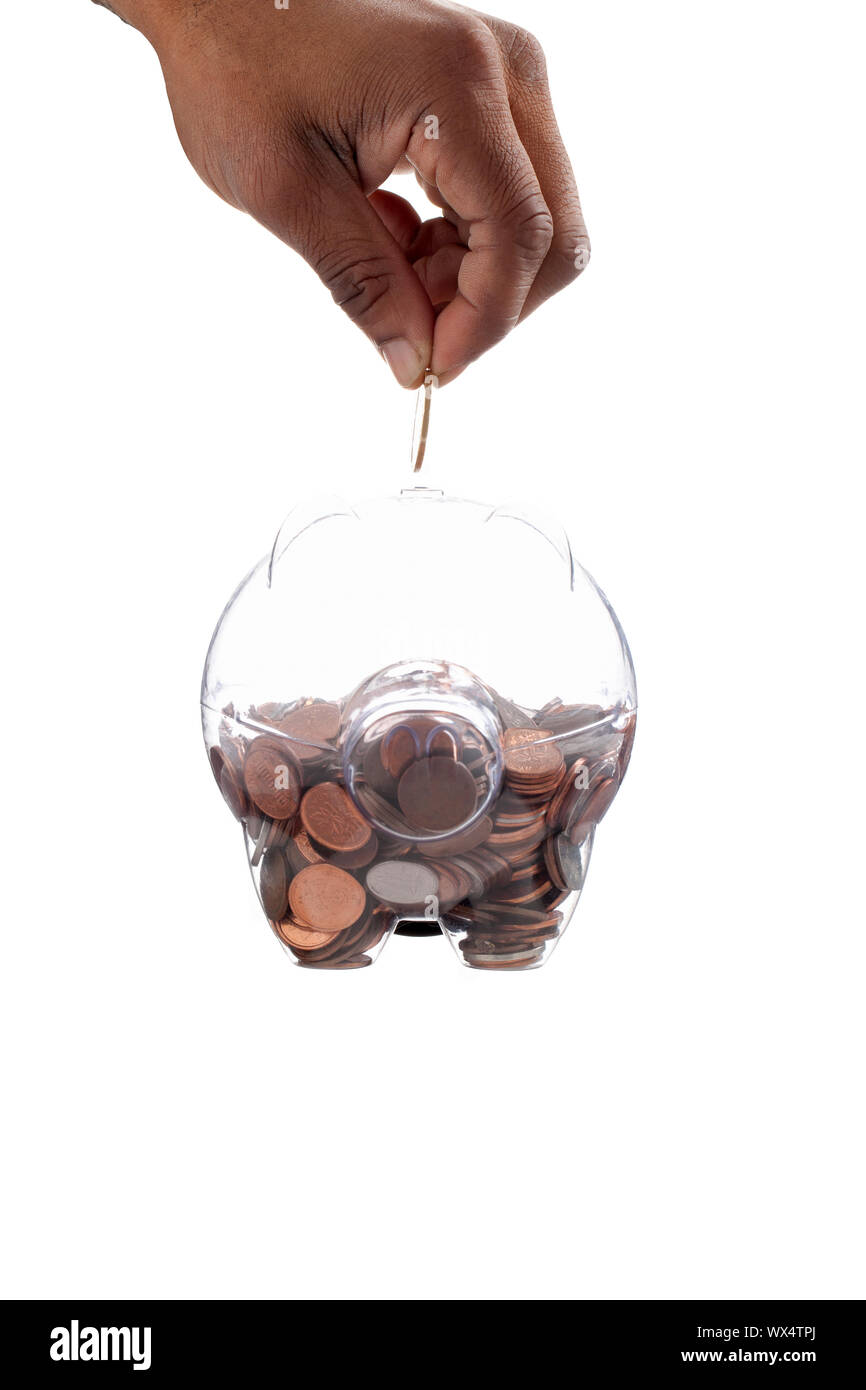 Gold coin inserting on a piggy bank using by the human hand Stock Photo ...