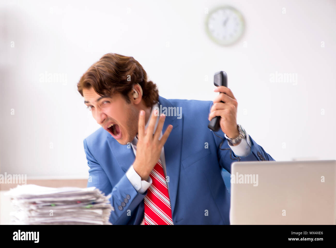 Deaf employee using hearing aid in office Stock Photo Alamy