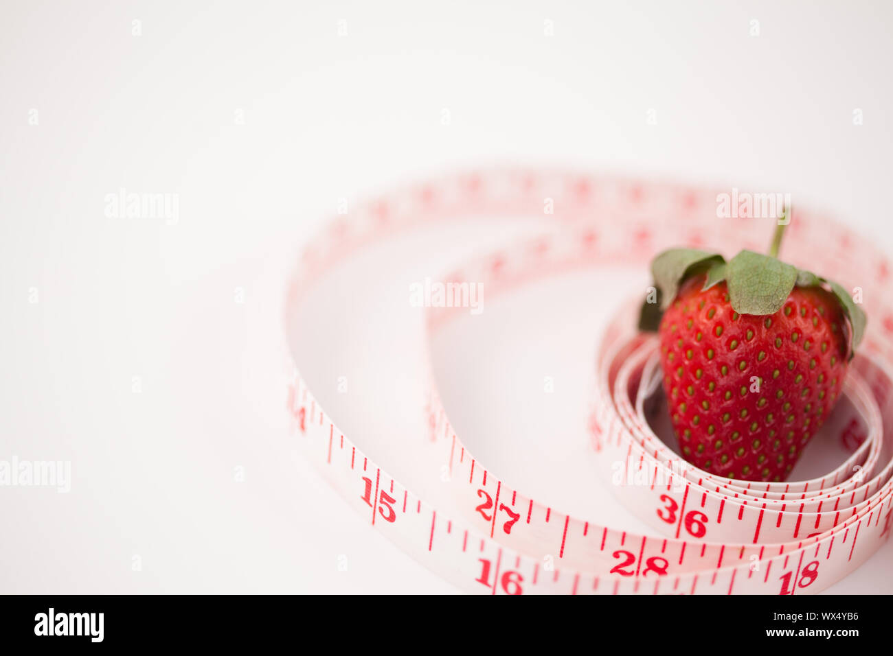 Strawberry surrounded by a ruler against a white background Stock Photo ...