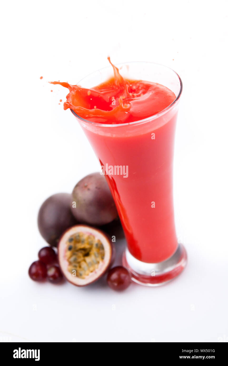 Overflowing glass of berries juice against white background Stock Photo