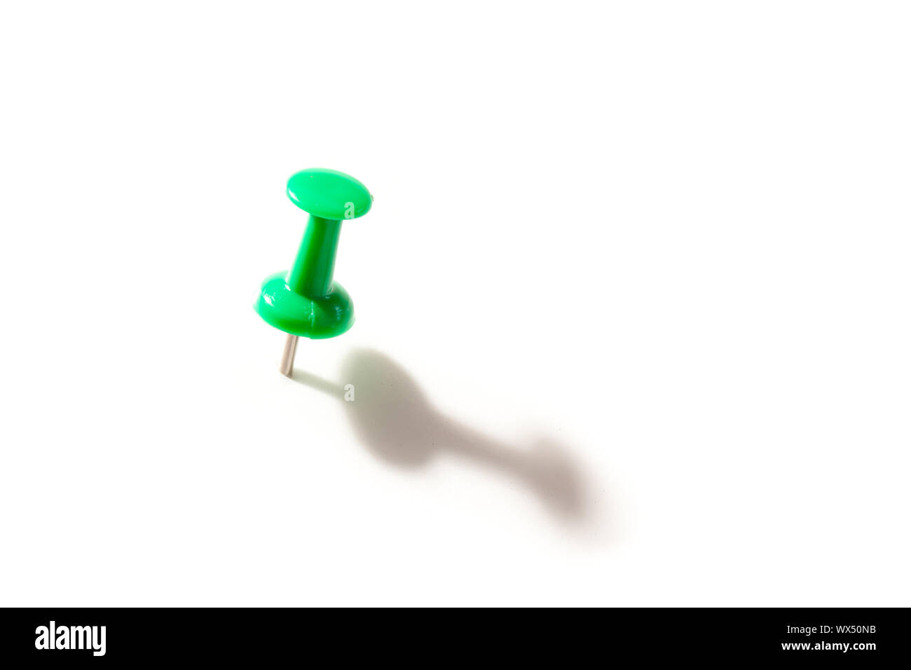 Green pushpin against a white background Stock Photo - Alamy