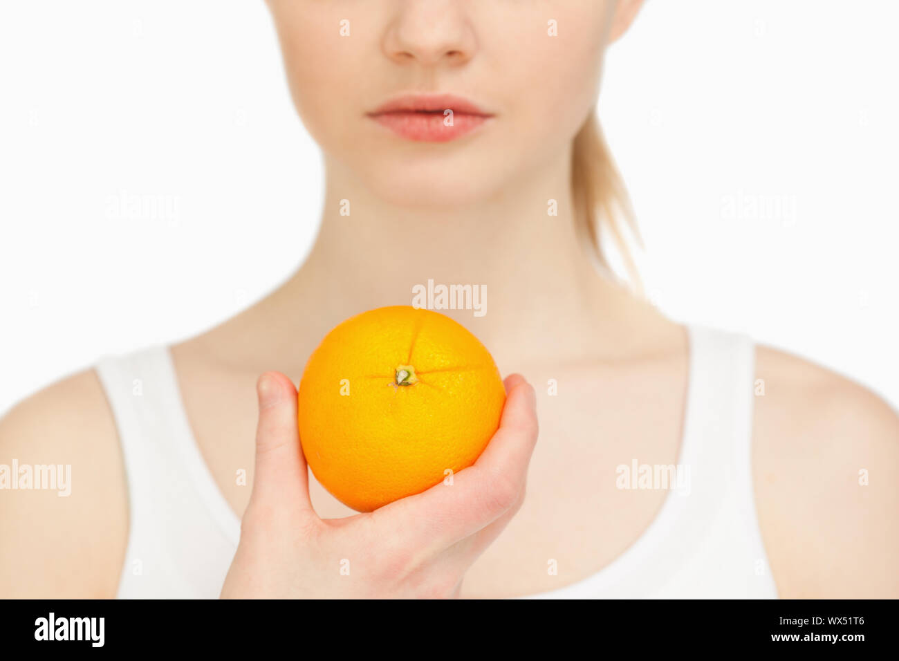 Woman holding an orange against white background Stock Photo - Alamy