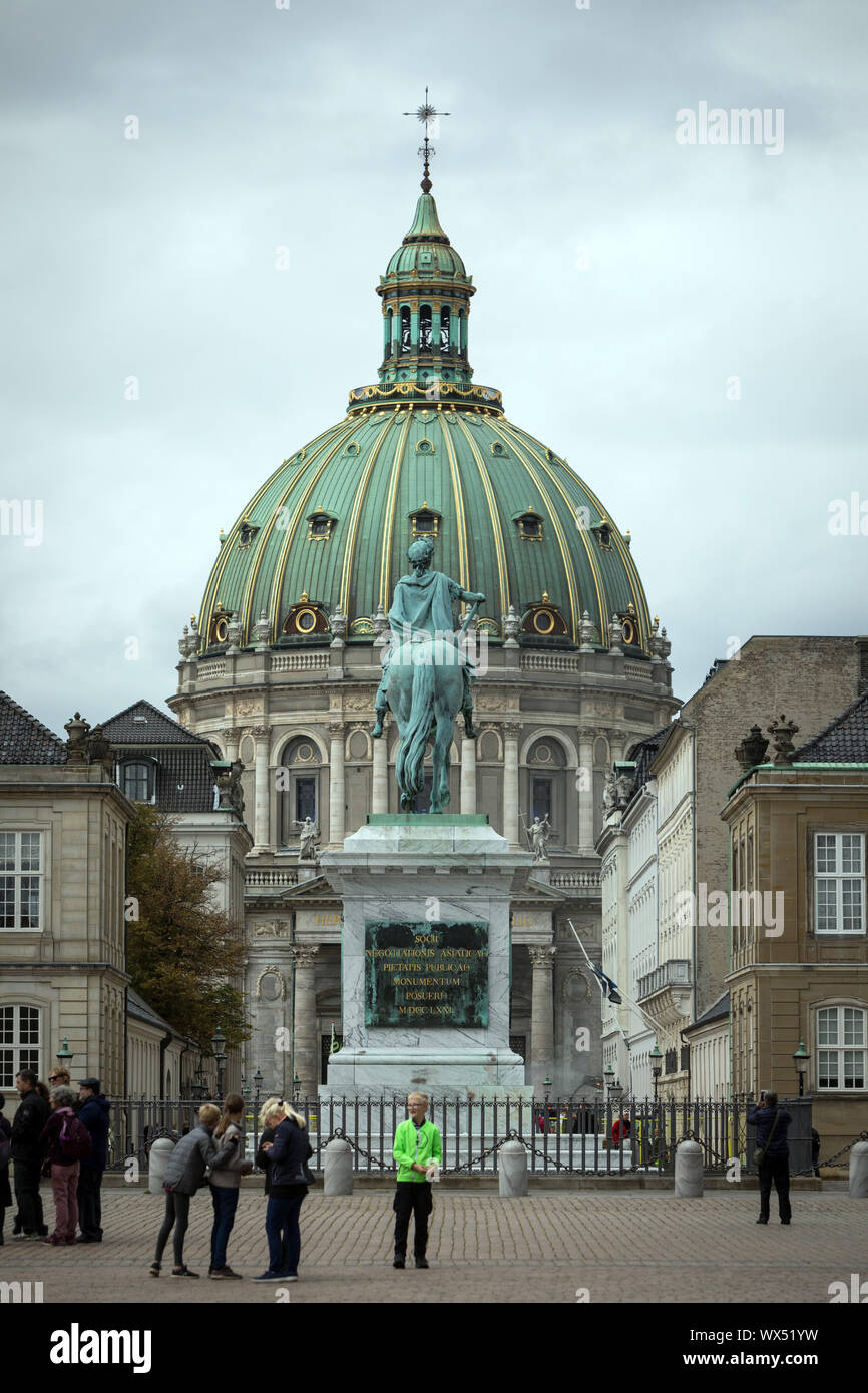 The equestrian statue of King Frederik V in the square of the Amalienborg Palace in Copenhagen, with Frederik’s Church in the distance Stock Photo