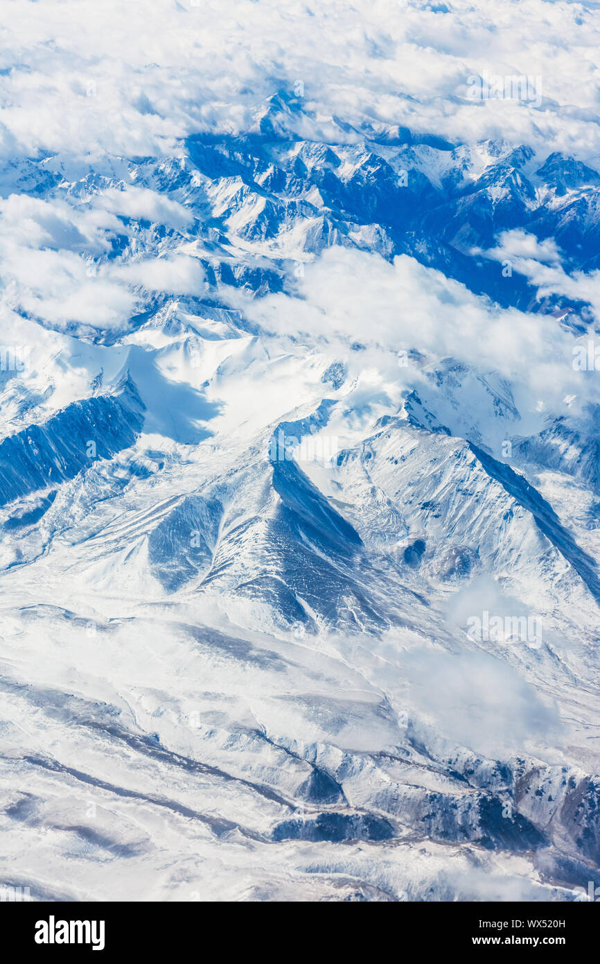 View of the mountains from airplane window during flight Stock Photo