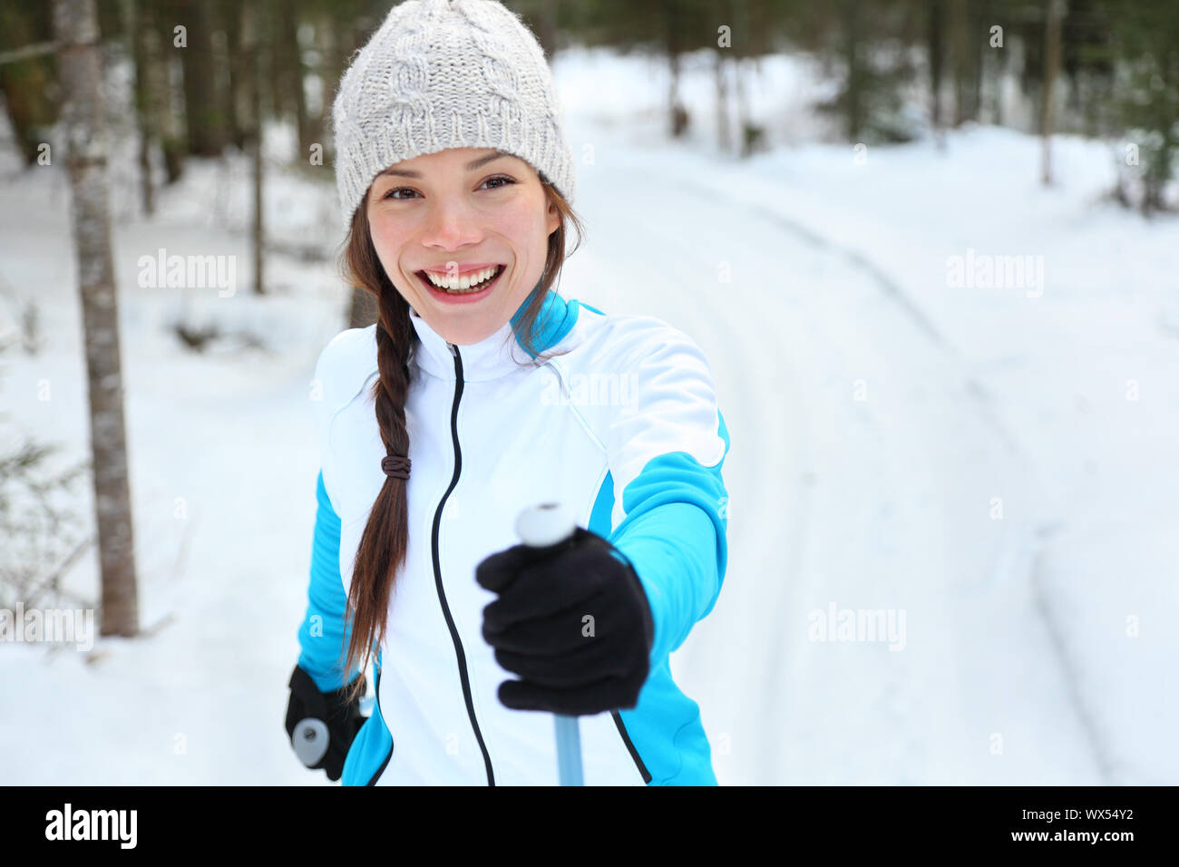 Cross-country skiing woman doing classic nordic cross country skiing in trail tracks in snow covered forest in Quebec, Canada Stock Photo