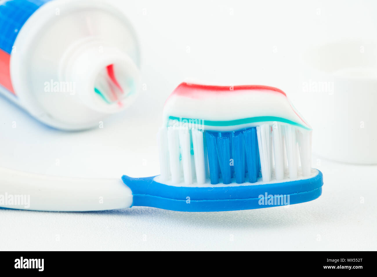 Tube of toothpaste with toothbrush against white background Stock Photo ...