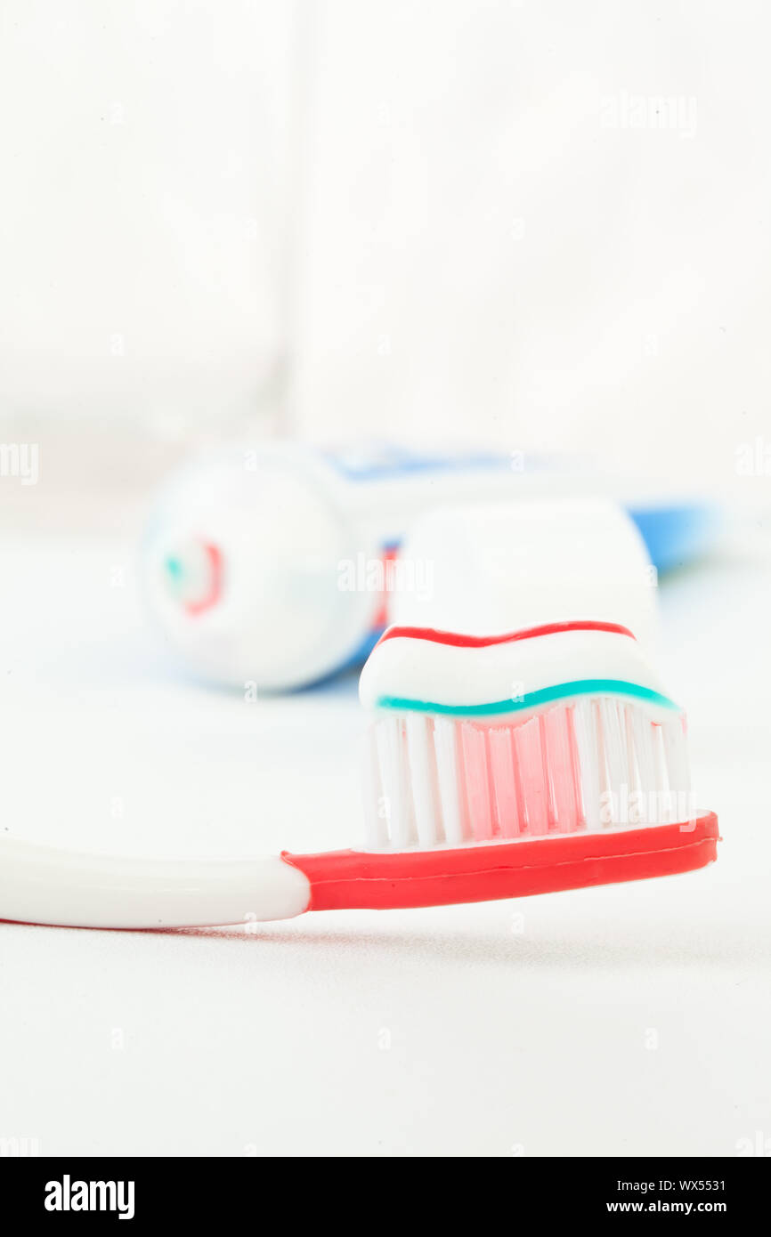 Tube of toothpaste next to a toothbrush against white background Stock ...