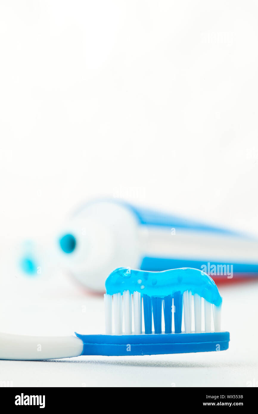 Toothpaste next to a toothbrush against white background Stock Photo ...