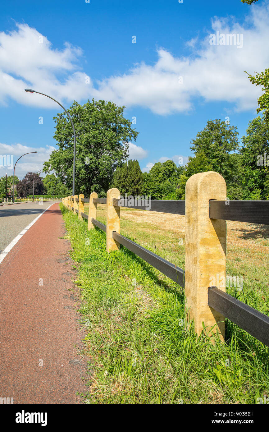 Fence along dutch bike path and road Stock Photo