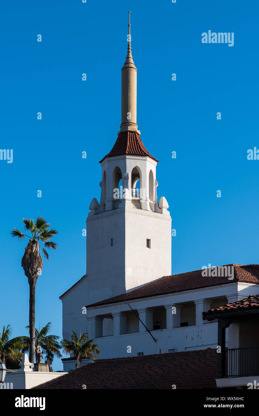 The setting sun highlights a Spanish Colonial Revival architectural style spire and palm trees - the Arlington Theatre in Santa Barbara, California Stock Photo