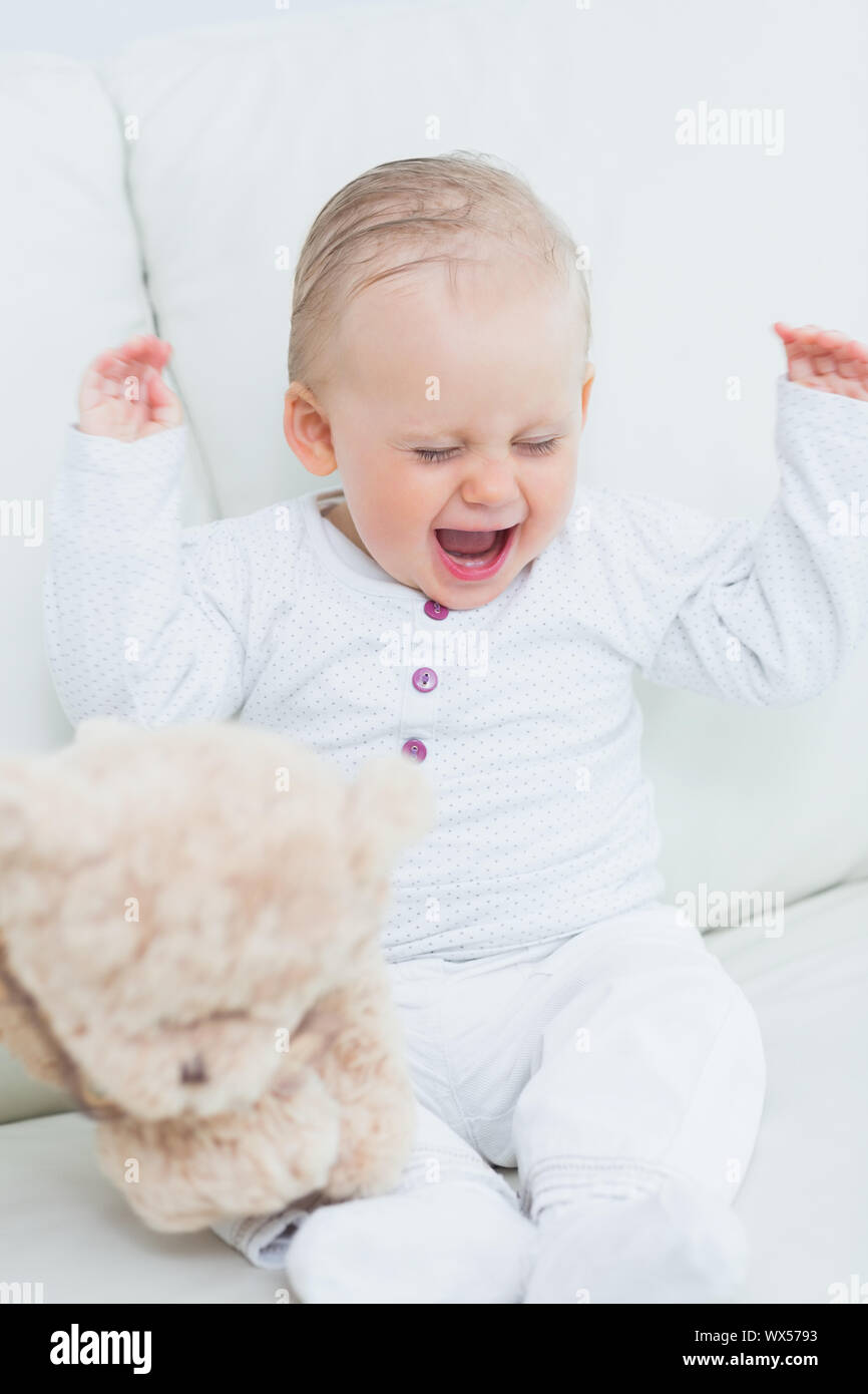 Baby with teddy bear in living room Stock Photo - Alamy