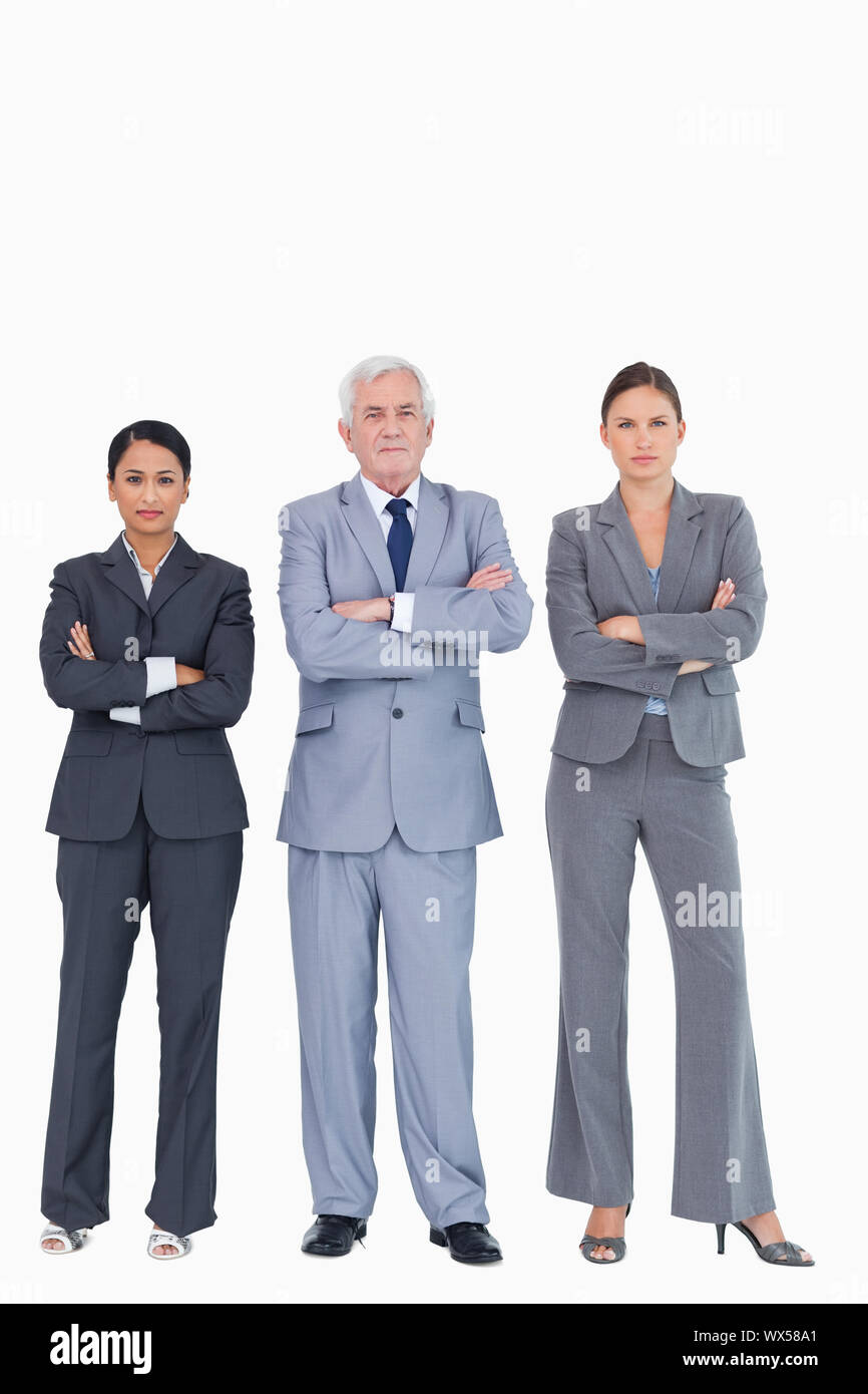 Three businesspeople with arms folded against a white background Stock Photo