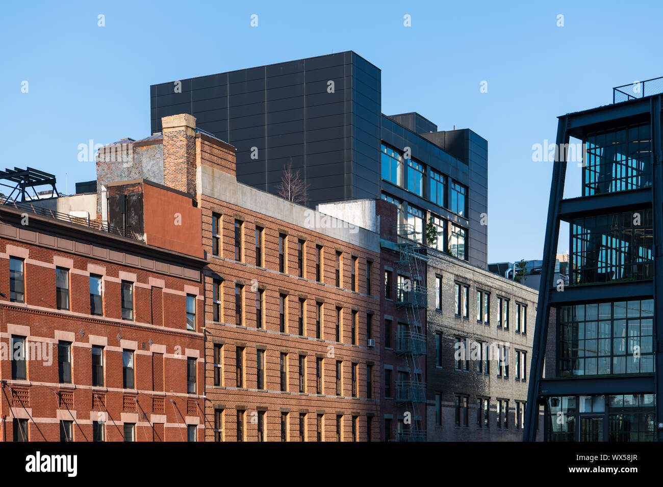 Old brick buildings contrasted with modern glass and steel architecture near The High Line in New York City Stock Photo