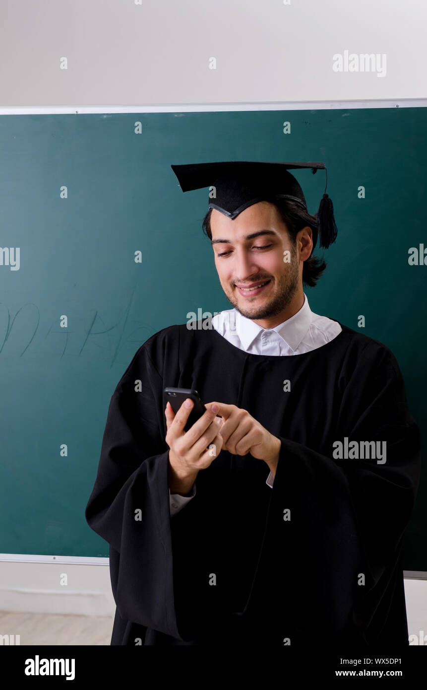 Graduate Front Use Graduate student in front of green board Stock Photo - Alamy