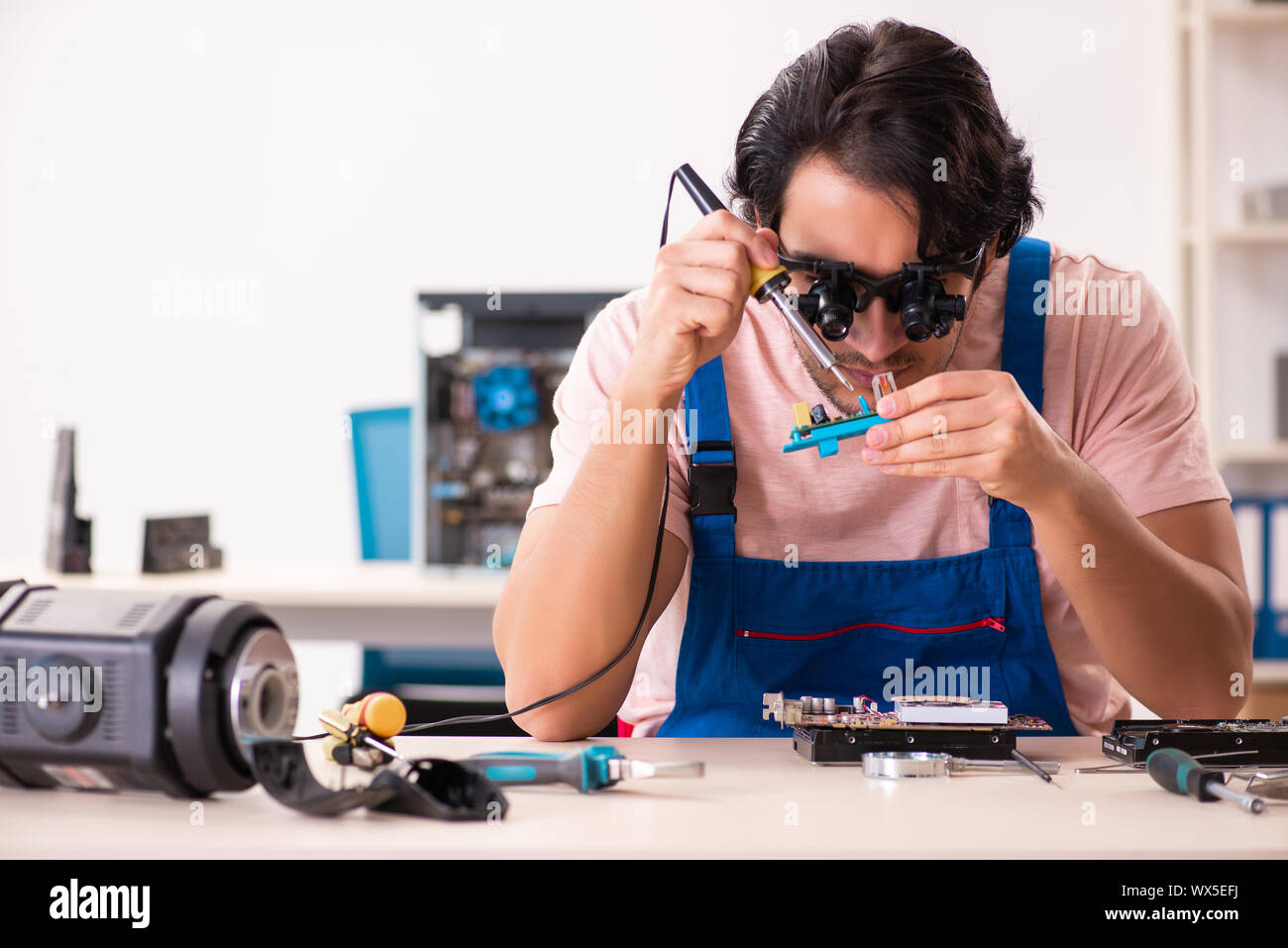 Young male contractor repairing computer Stock Photo