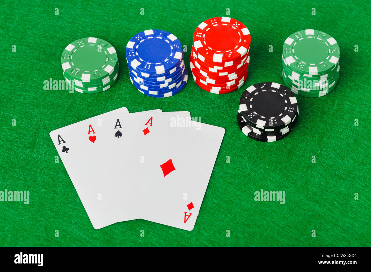 Casino chips and playing cards on green table Stock Photo