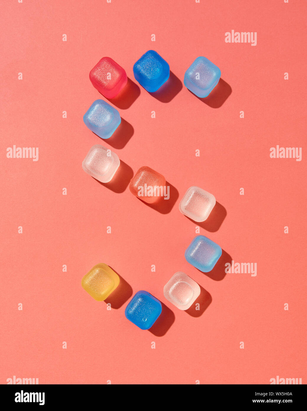 Figure five pattern from colored plastic ice cubes on a background in a color of the year 2019 Living Coral Pantone, copy space. Stock Photo