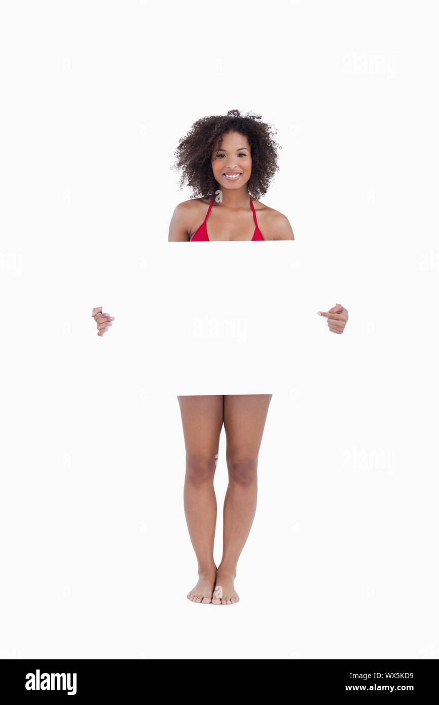 Smiling woman in beachwear holding a blank poster against a white background Stock Photo