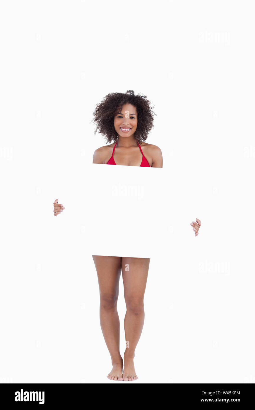 Smiling woman in bikini holding a blank poster against a white background Stock Photo